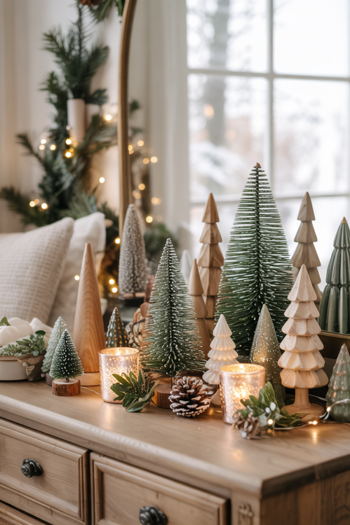 A dresser vignette of varied bottle-brush, wooden, and ceramic tabletop trees in different heights and finishes, lit by tiny fairy lights .